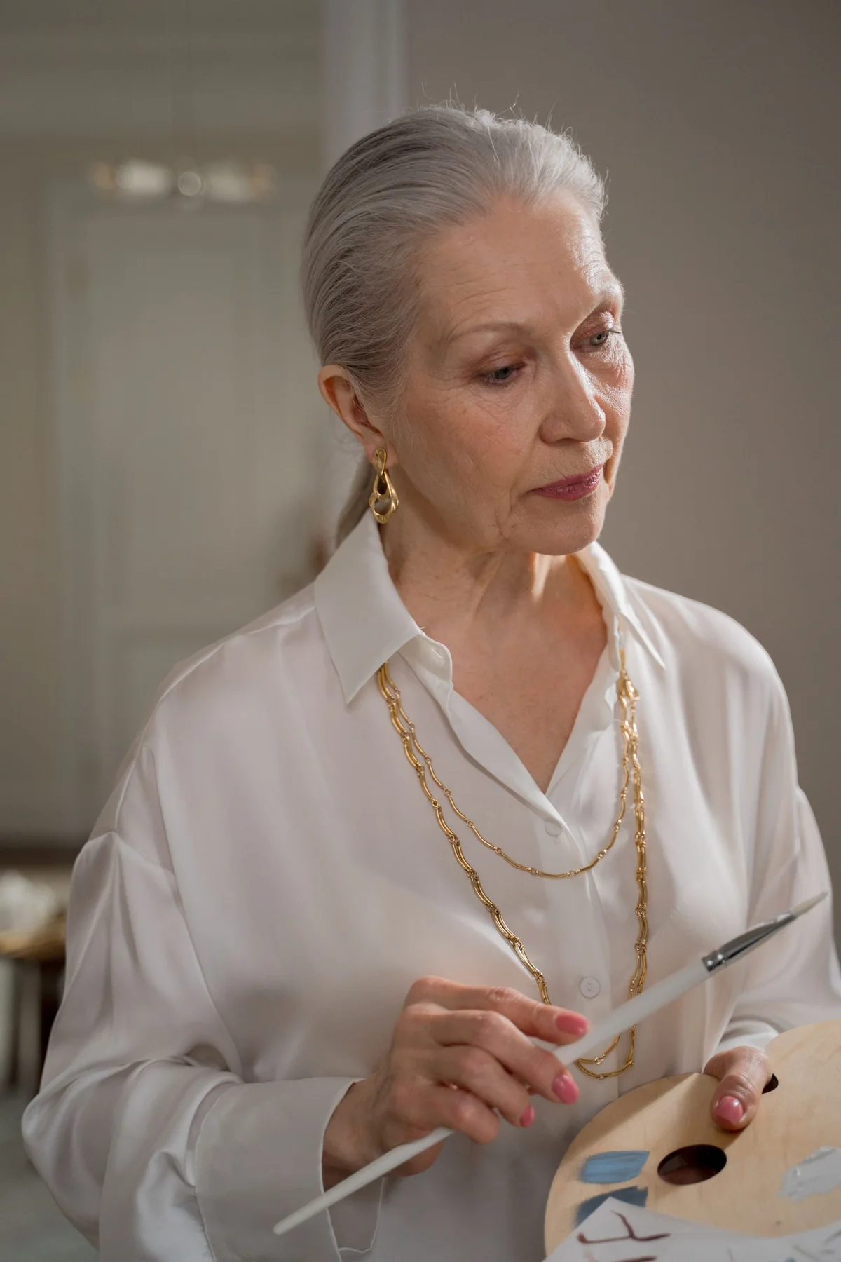 An older woman concentrating on a painting