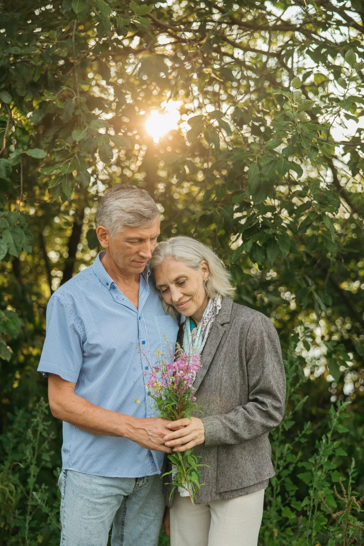 An older couple sharing a quiet moment in a sunlit garden